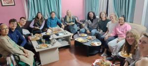 KirtipurKIRTIPUR COMFORT HOMESTAY with breakfast & dinner的一群坐在客厅里吃食物的人