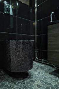 索特Villa Auroras Poro的浴室铺有黑色瓷砖地板,设有黑色卫生间。