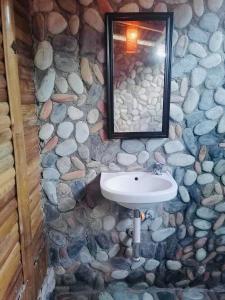 罗哈斯Mecaja Beach House的石质浴室设有水槽和镜子