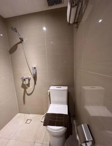 棉兰Deli Hotel的一间带卫生间的浴室和墙上的一部电话