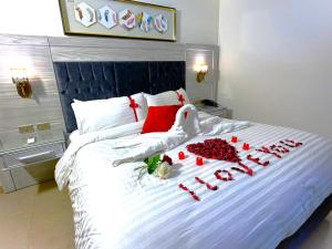 瓦迪穆萨Petra Canyon Hotel的一张有几朵天鹅和红玫瑰的床