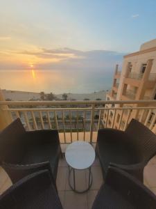 阿卜杜勒国王经济城Royal Beach Apartment的阳台配有桌椅。