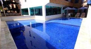 塔曼达雷Praia dos Carneiros flat hotel的大楼里的一个大型蓝色游泳池