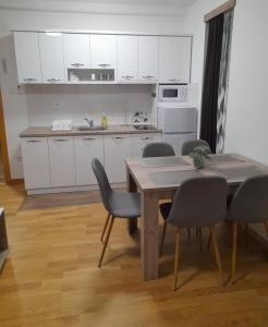 索科矿泉村KONAK ViLA MIRKOVIĆ的厨房配有白色橱柜和桌椅