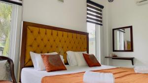 KandanaVilla with a private pool and Garden-Ivory Villa Not for Local的一间卧室配有两张带橙色和白色枕头的床