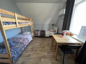 阿克套Гостевой Отель-125的客房设有两张双层床和一张桌子。