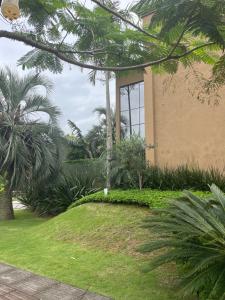 弗洛里亚诺波利斯Suite em linda casa em Jurerê internacional的庭院前有棕榈树的建筑