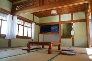 高知TOSAYAMA BASE 清流沿いの里山　古民家貸切　高知市街地より車で約20分的客房设有木桌和一些窗户。