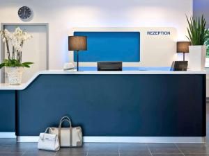 科隆科隆展览中心宜必思快捷酒店的办公室里的一个前台,有蓝色的墙壁