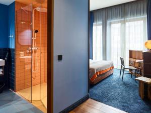 汉堡25hours Hotel Hamburg HafenCity的酒店客房设有淋浴和一间卧室。