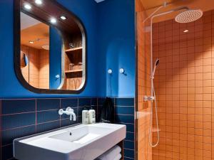 汉堡25hours Hotel Hamburg HafenCity的浴室设有白色水槽和镜子