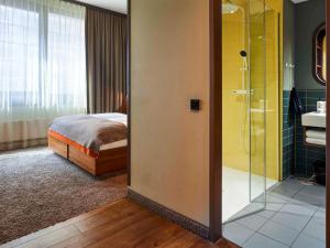 汉堡25hours Hotel Hamburg HafenCity的一间卧室设有一张床和一个玻璃淋浴间