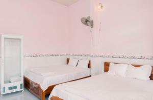 Xuyên MộcPhương Tú Hostel的配有2张床的白色墙壁和镜子