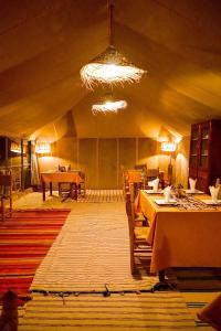 梅尔祖卡Sky View Camp的帐篷内带桌椅的房间