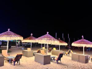 巴加Baga beach front的海滩上的一组椅子和遮阳伞