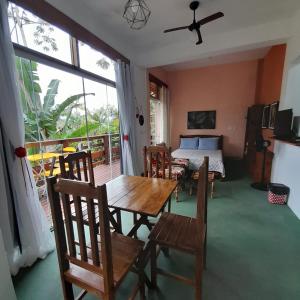 乌巴图巴La Casa Rozada Prumirim的一间带桌椅和一张床的用餐室