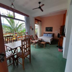 乌巴图巴La Casa Rozada Prumirim的卧室配有一张床和一张桌子及椅子