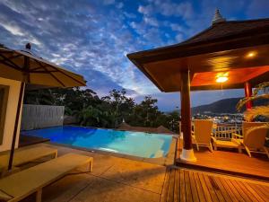 卡马拉海滩Villa Tantawan Resort - Private Pool Villas的一座带游泳池和甲板的房子
