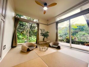 本部Yama'oto - Nature Luxury Stay的客厅配有吊扇和大窗户