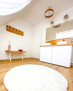 Criquebeuf-sur-SeineLe cocon de Normandy的厨房配有白色橱柜和白色地毯。