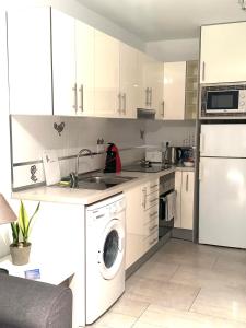 卡门港Los Gracioseros Apt 207的厨房配有白色橱柜和洗衣机。