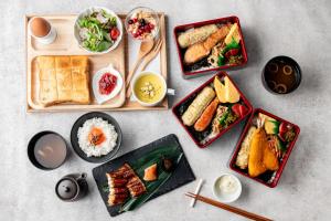 尼崎市ホテル 尼乃美楽 尼崎的餐桌,盘子上放着食物和碗