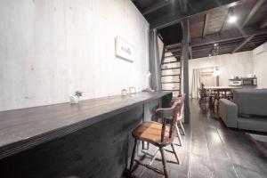 金泽YADOSU Arts and Stay的一间酒吧,位于带椅子和桌子的房间