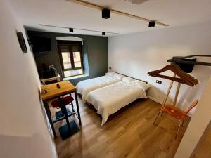 米耶雷斯The Orange Teddy Bear Hostels La Peña的一间卧室配有一张床和一张桌子