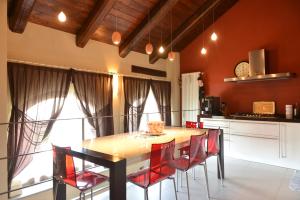 蒙多维Casa Vacanze Il Brichet的厨房配有木桌和红色椅子