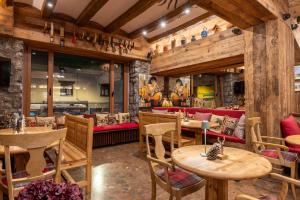 维耶拉Hotel Aran La Abuela的餐厅设有木桌和红色沙发