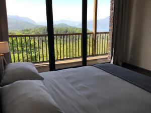 勒威诺Agriturismo Voeuja Lago Maggiore的一间卧室设有一张床和一个享有美景的大窗户
