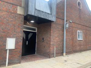 赫尔#5 Grimston St Apartment near Hull New Theatre and Connexin Live的一座带黑色门的大型砖砌建筑