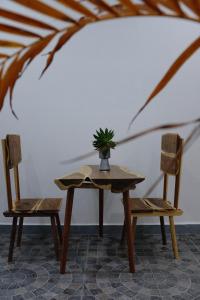 美奈Gạo Homestay的桌子和两把椅子上放着盆子