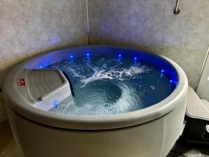 瓦洛尼OXXOTEL的浴室内设有一个蓝色灯光按摩浴缸