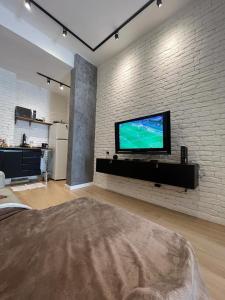 里约热内卢Subsolo 101的一间客厅,在砖墙上配有平面电视
