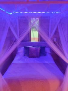 莫维尔Luxury log cabin with wood fired hot tub的紫色卧室配有带紫色枕头的床