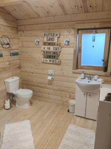 莫维尔Luxury log cabin with wood fired hot tub的木制浴室设有卫生间和水槽