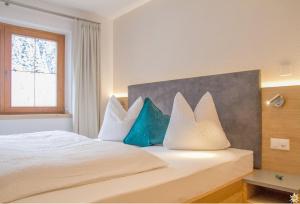 萨姆瑙恩Apart Prieth Samnaun的一间卧室配有一张带蓝色和白色枕头的床