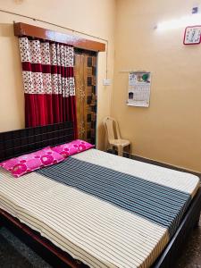 PerambalūrSirvachur madhurakalli amman guest house的一间卧室配有一张带红色窗帘的大床