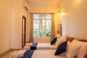 达拉万度生物圈旅馆的一间卧室设有两张床和窗户。