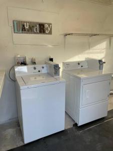 罗克雷治Shares Courtyard Luxury Apt - NEW!的洗衣房配有两台机器,墙上有标牌