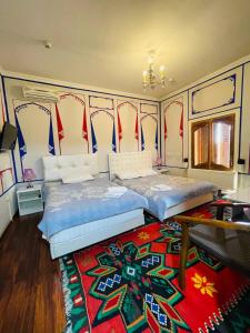 布哈拉"CHOR MINOR" BOUTIQUE HOTEL Bukhara Old Town UNESCO HERITAGE List Est-Since 2003 Official Partner of Milano La Rosse Aroma的一间带两张床的卧室和地毯