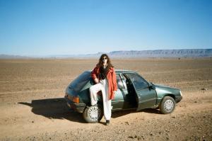 BrijaTinfou desert camp的坐在沙漠中汽车顶上的女人
