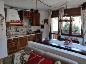 皮耶韦迪卡多雷Appartamento comodo e curato per famiglie的带沙发的客厅和厨房