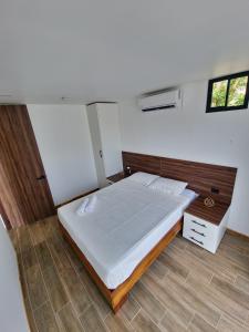 福尔图纳Villa El Bosque Dorado的卧室配有一张白色大床和木制床头板