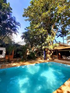 瓜鲁雅Pousada e SPA Canto do Mar的一座大蓝色游泳池,位于房子前