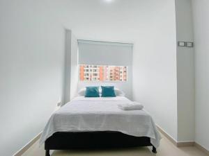 布卡拉曼加Excepcional Apartamento -WAIWA HOST的一间卧室配有一张带两个蓝色枕头的床