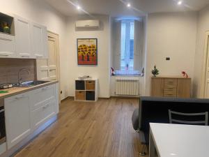 科森扎Via Rivocati 108的厨房铺有木地板,配有白色橱柜。