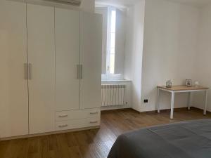科森扎Via Rivocati 108的卧室配有白色橱柜、桌子和床。