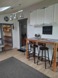 欧登日Gîte Domangé-Audenge的厨房配有一张大木桌和酒吧凳子